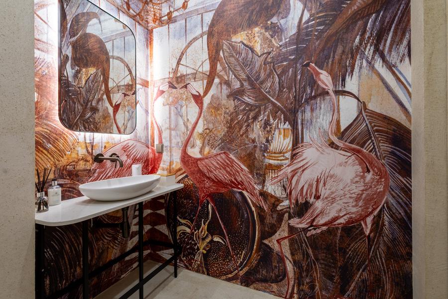 Restroom behind seamless plaster doors, wrapped in a flamingo mural