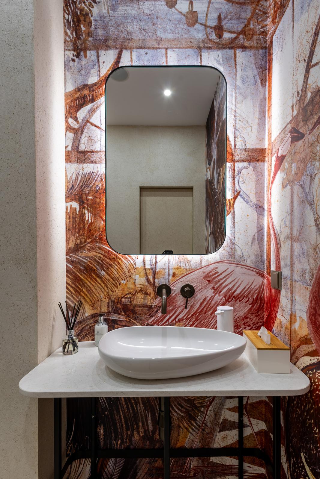 Mirror and basin against the mural