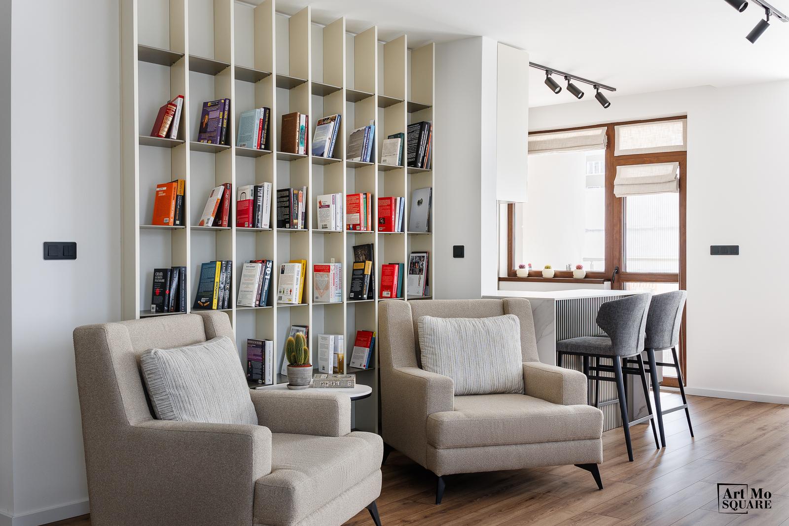 Living room with a floor-to-ceiling library and two reading chairs
