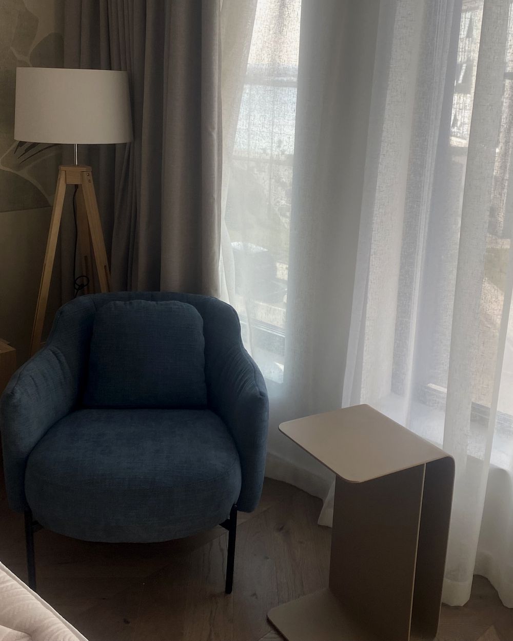 The side table beside the armchair in the finished bedroom